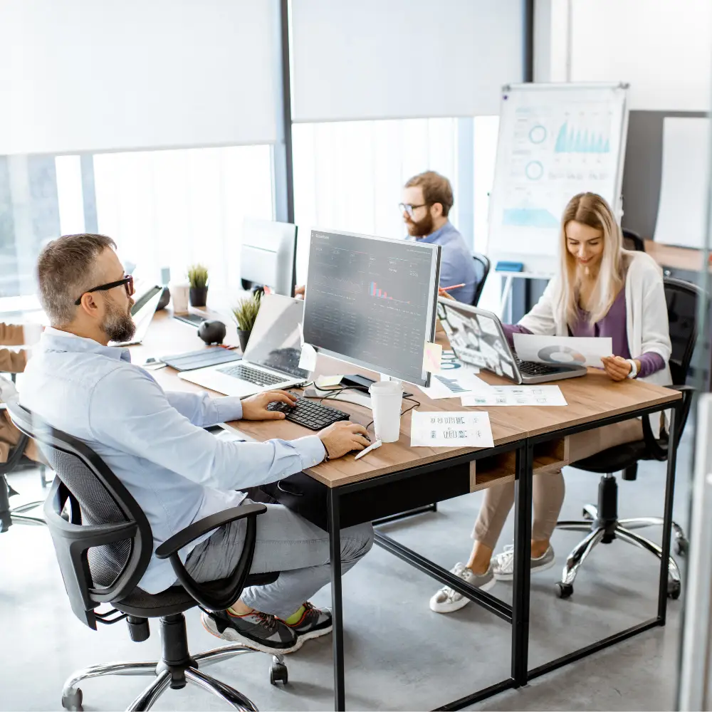 3 office workers at their desks